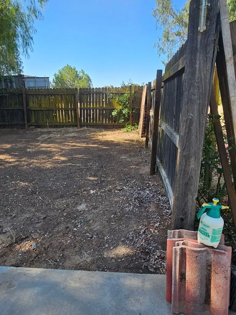 Yard cleared and hauled clean behind a wood gate on a Superior Hauling cleanout job in Madera, CA