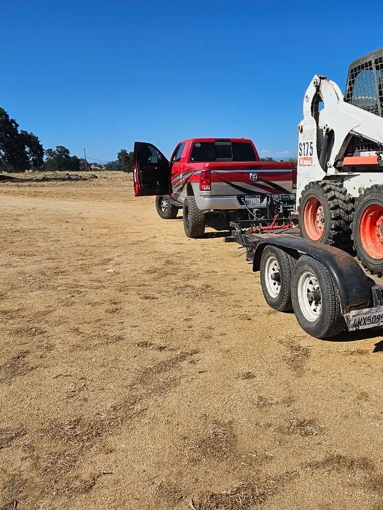 Superior Hauling truck, trailer, and Bobcat on a job across the Central Valley