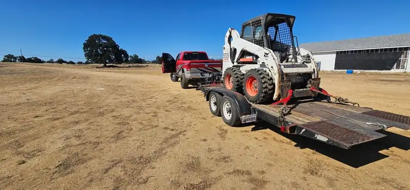 Superior Hauling truck, trailer, and Bobcat loaded and ready in a Central Valley field