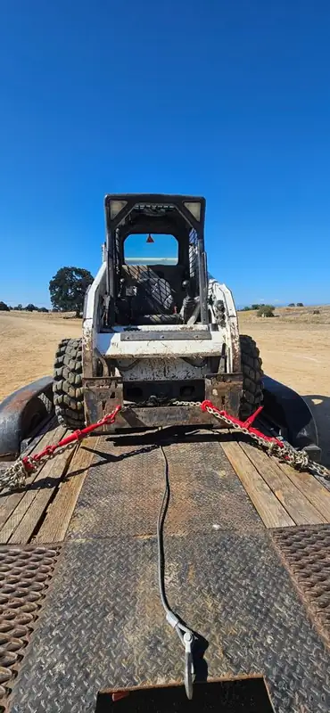 Bobcat chained down on the trailer, ready to haul to the next job