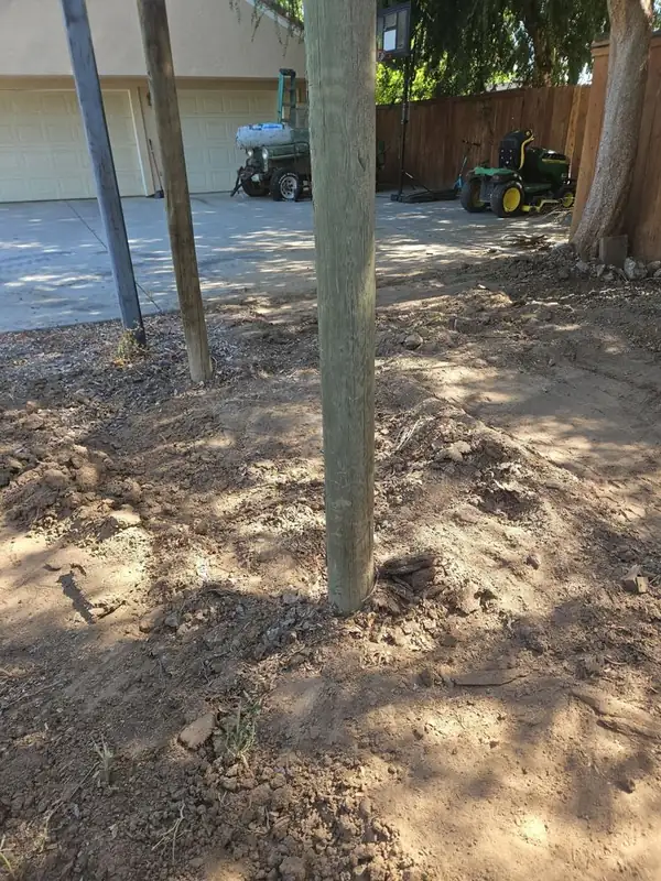 New fence post set in fresh soil during a yard project