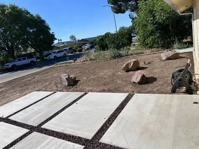 Front yard graded with placed boulders next to a paver walkway in Madera